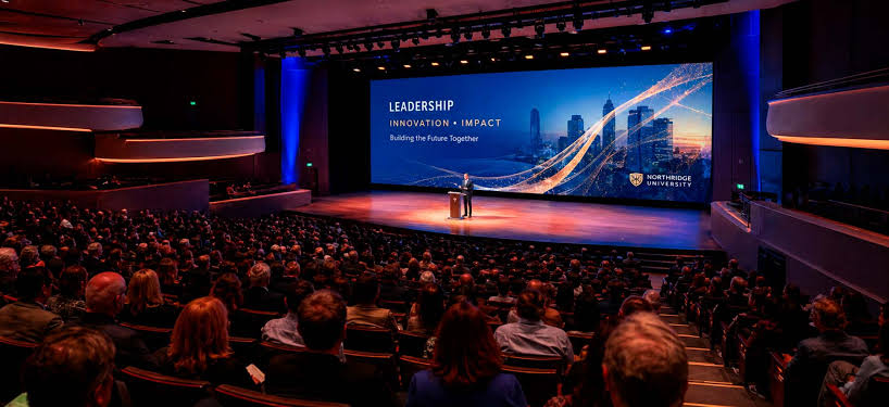Tiered lecture hall facing a large projection screen